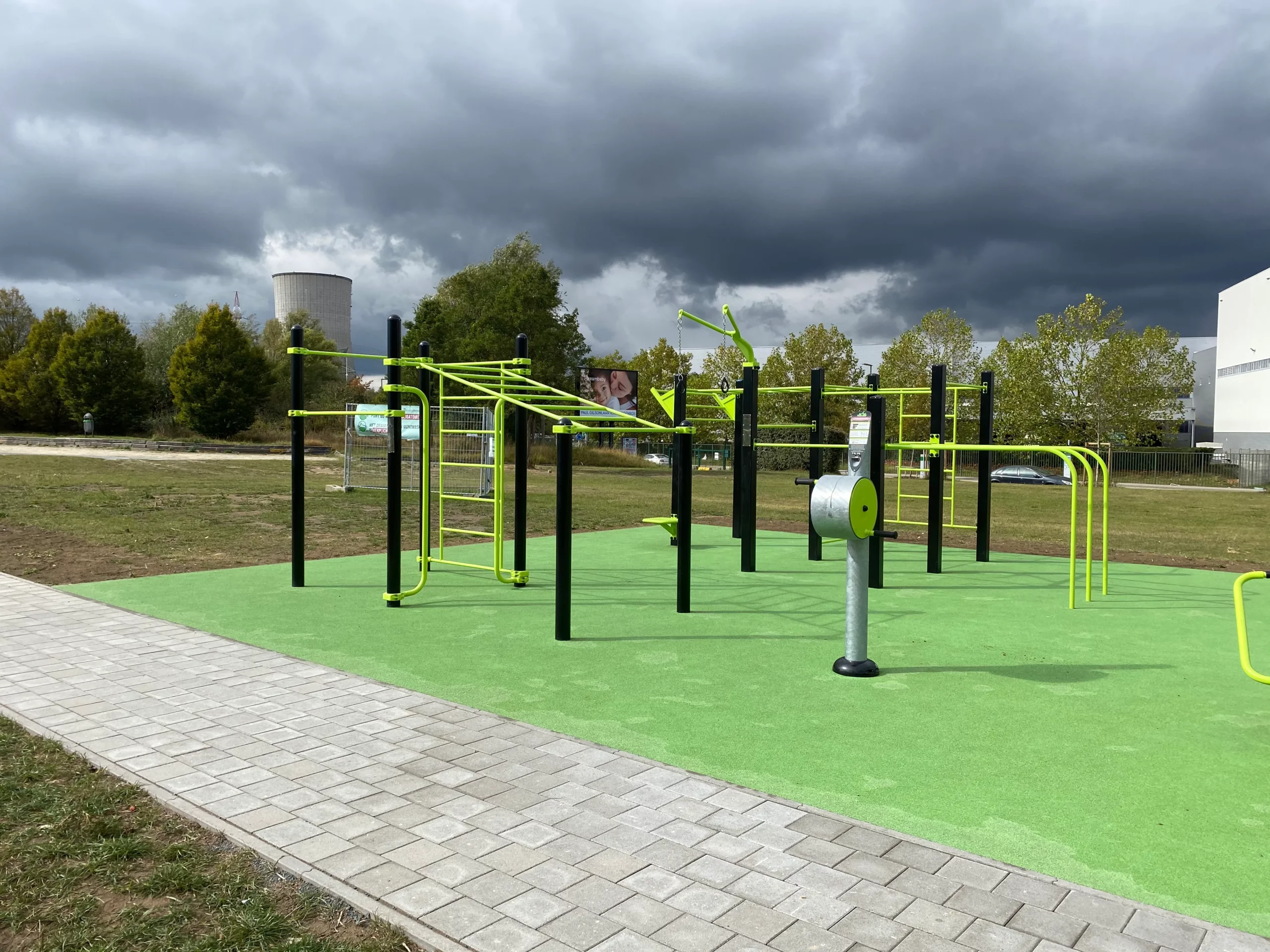 handbike chargeur sur une aire sportive de plein air devant une station de street workout