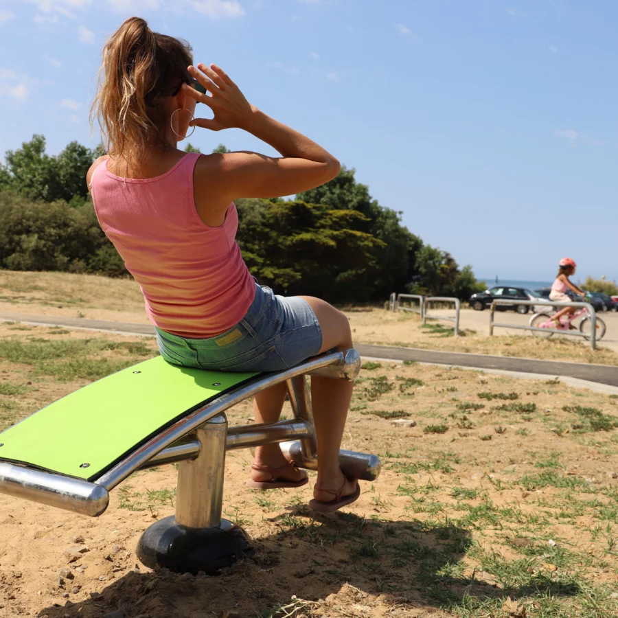 femme faisant des exercices d'abdominaux sur l'abdo inox face à la mer