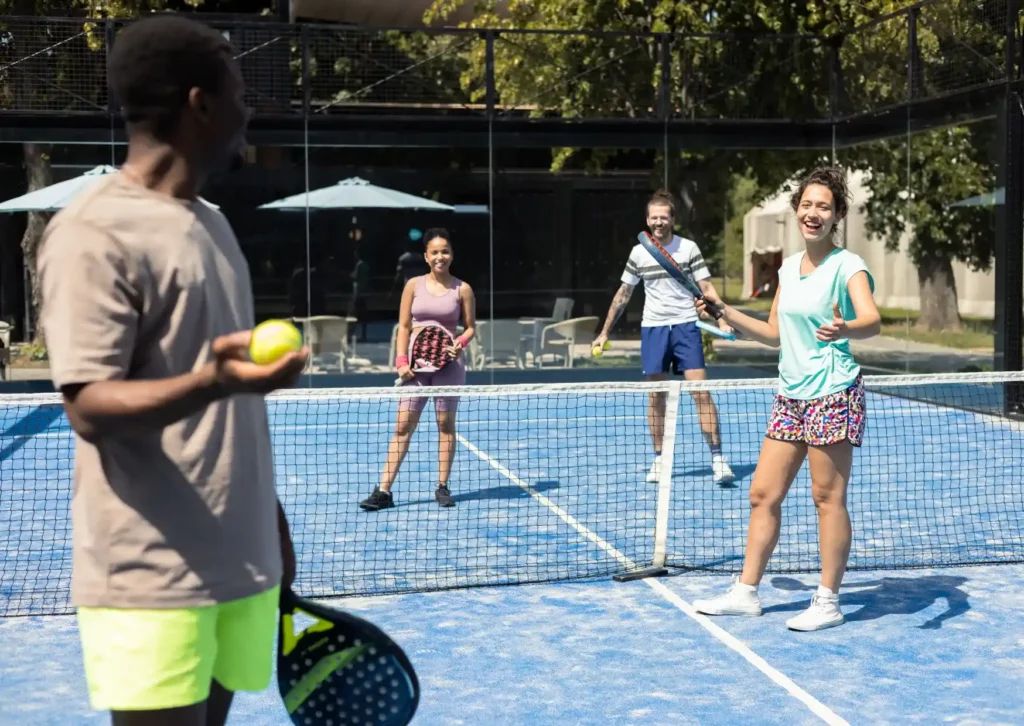 quatre joueurs sur un terrain de padel en plein match