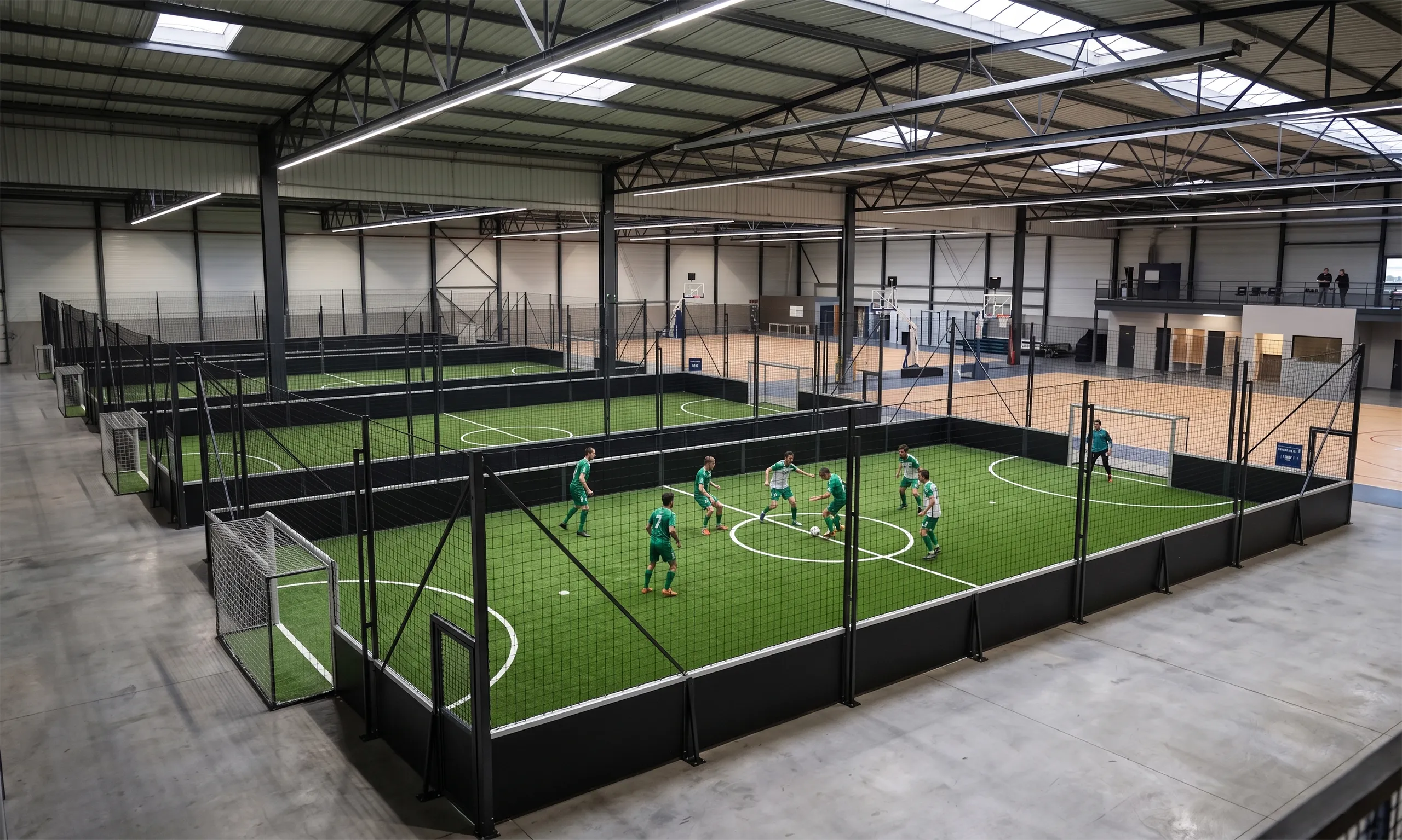vue de quatre terrains de foot 5 en intérieur d'un gymnase proposant aussi des terrains de basket